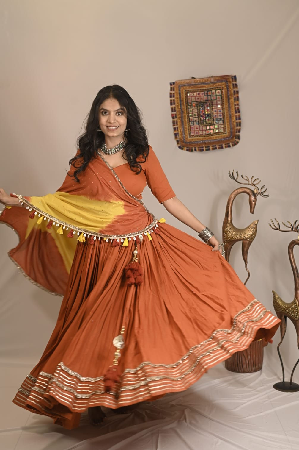Model twirling in the orange Mal Cotton chaniya choli set with yellow ombré dupatta
